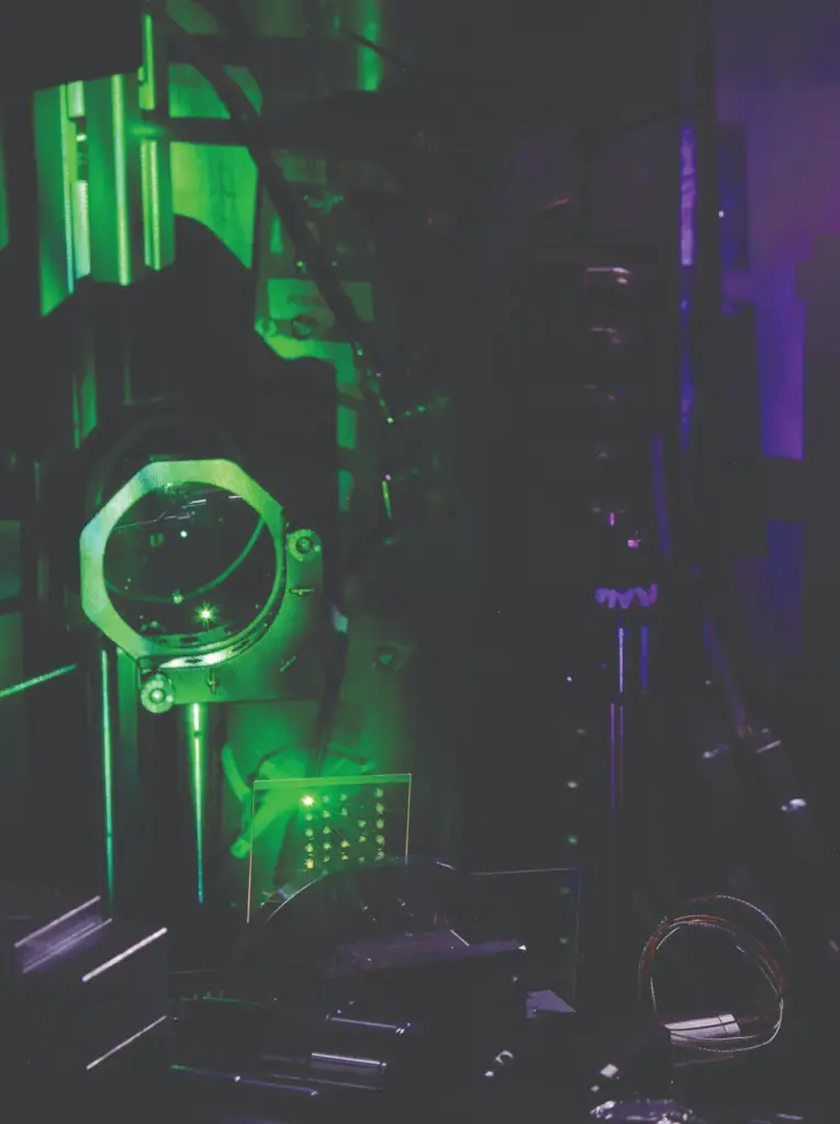 A high-power laser pulse is focused on a glass target and generates a plasma, appearing here as a glowing green spot.